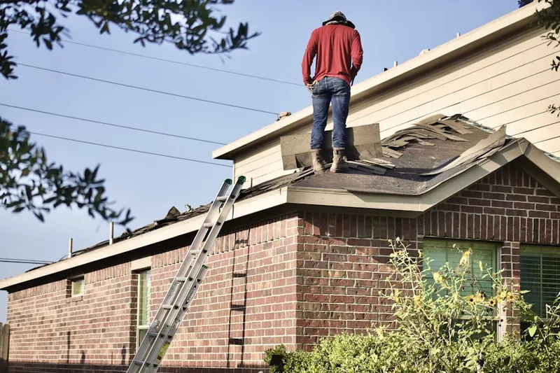 Professional roofer working on a residential roof in Alexauken